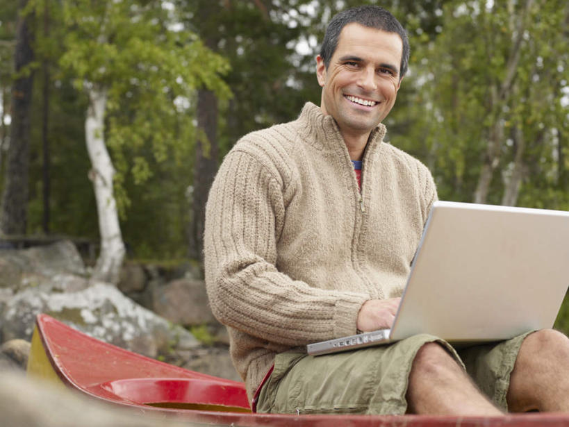 西方人,一个人,坐,捧,笑,微笑,露齿笑,横图,室外,白天,正面,电脑,笔记本电脑,石头,树林,植物,船,欧洲,欧洲人,仅一个男性,仅一个人,仅一个中年男性,一艘,敲打,停靠,服装,网络,石子,木船,注视,休闲装,输入,通讯设备,树,树木,衣服,黄色,红色,绿色,灰色,自然,交通工具,打字,观察,看,休闲,休闲服,服饰,生长,成长,观看,点击,敲击,察看,无线,舟,关注,停泊,载具,独木舟,通信设备,无线网络,无线上网,便携式电脑,独木船,按键,手提电脑,男人,男性,中年男性,白种人,石块,岩石,端,端着,捧着,手捧,坐着,半身,彩图