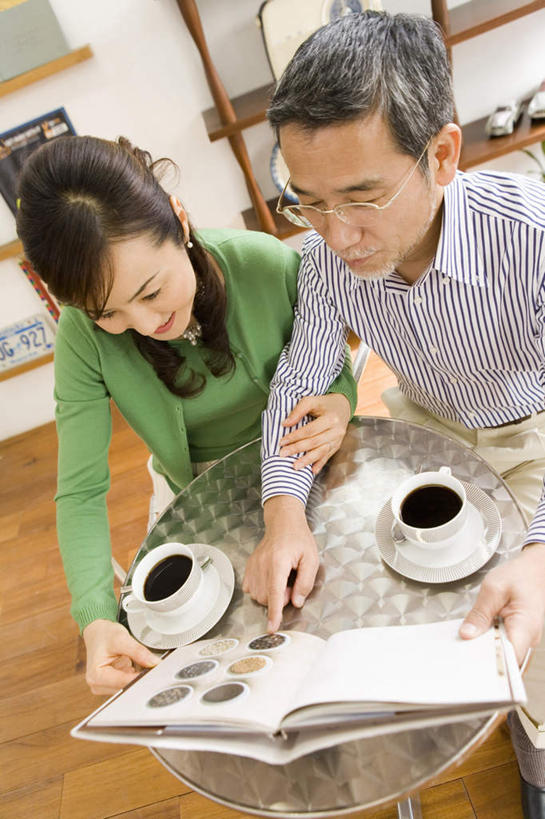 咖啡,东方人,两个人,夫妻,客厅,坐,笑,微笑,露齿笑,竖图,俯视,室内,白天,爱情,幸福,植物,餐桌,地板,柜子,桌子,杯子,书籍,椅子,亚洲,服装,数字,木椅,墙,地面,两杯,浪漫,拿,拿着,休闲装,黄种人,娱乐,木地板,相视,墙壁,墙面,饮料,衣服,绿色,自然,水杯,低头,享受,休闲,温馨,面对面,休闲服,恩爱,放松,乐趣,恋人,服饰,餐台,对视,提神,起居室,搀扶,舒适,醒脑,相对,相看,软饮料,男人,男性,女人,女性,中年男性,中年女性,亚洲人,情侣,茶杯,书,图书,坐着,半身,彩图,高角度拍摄,伴侣