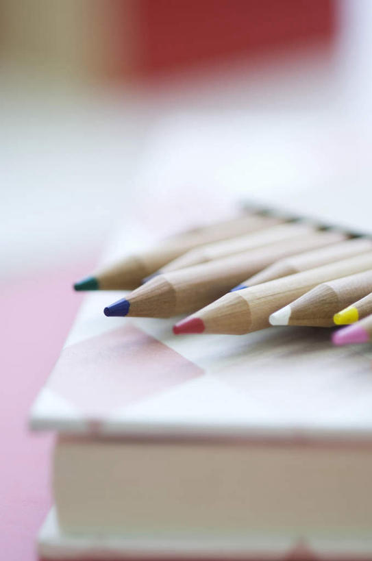 无人,竖图,俯视,室内,特写,白天,桌子,书籍,一本,一排,许多,整齐,笔,办公用品,文具,排列,粉色,黄色,红色,蓝色,绿色,白色,铅笔,学习用品,文具用品,队列,书,图书,彩图,高角度拍摄