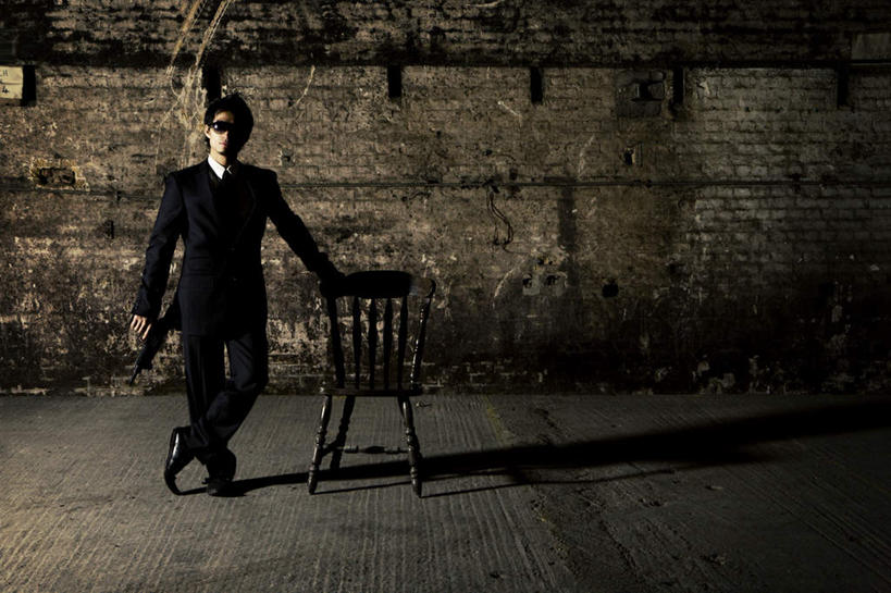 西方人,脸,头,鼻子,嘴,耳朵,脸颊,手,一个人,站,横图,室内,白天,正面,西装,椅子,欧洲,欧洲人,仅一个男性,仅一个人,一把,握,套装,正装,墨镜,枪,眼镜,砖块,木椅,墙,拿,拿着,职业装,墙壁,墙面,仅一个年轻男性,太阳镜,太阳眼镜,站着,手部,遮阳镜,握着,扶着,男人,男性,年轻男性,白种人,头部,鼻,鼻孔,耳,耳部,口,口腔,脸部,脸蛋,面部,嘴巴,嘴唇,站立,彩图,全身