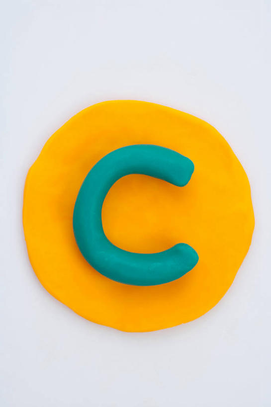 无人,竖图,俯视,室内,特写,白天,白色背景,静物,英文,圆形,标志,图形,文字,圆,字符,字母,泥土,土壤,几何,标识,黄色,蓝色,摄影,影棚,英文字母,粘土,数学,矿物,彩图,高角度拍摄,影棚拍摄,拍摄,几何图形,平面图形,黏土