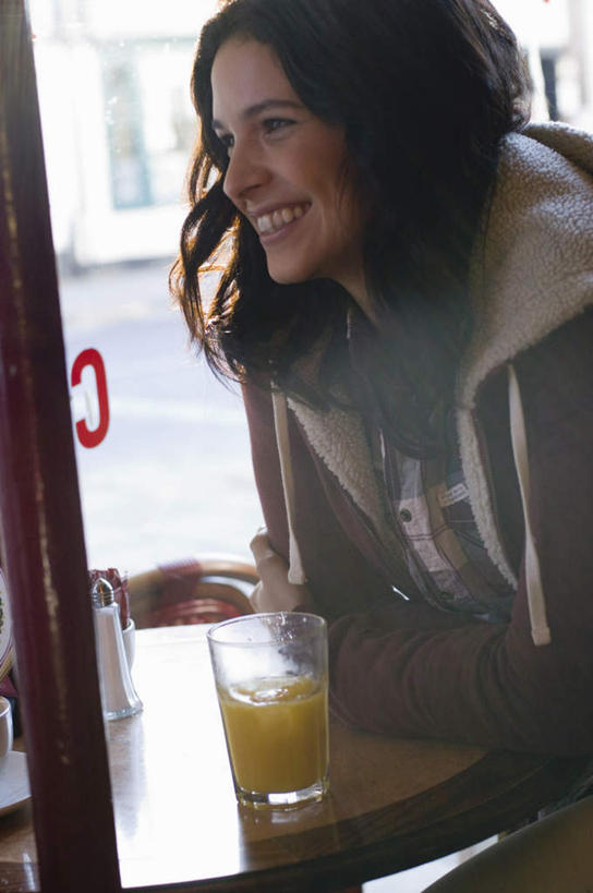 果汁,西方人,一个人,坐,笑,微笑,露齿笑,竖图,室内,白天,侧面,餐桌,窗户,落地窗,桌面,桌子,橱窗,杯子,欧洲,欧洲人,仅一个年轻女性,仅一个女性,仅一个人,服装,棕色,饮品,一杯,注视,休闲装,玻璃窗,玻璃制品,饮料,衣服,水杯,观察,看,休闲,休闲服,连帽衫,服饰,餐台,观看,察看,关注,可口,咖啡店,咖啡屋,帽衫,玻璃橱窗,适口,年轻女性,女人,女性,白种人,长发,卷发,玻璃杯,坐着,半身,彩图,咖啡馆