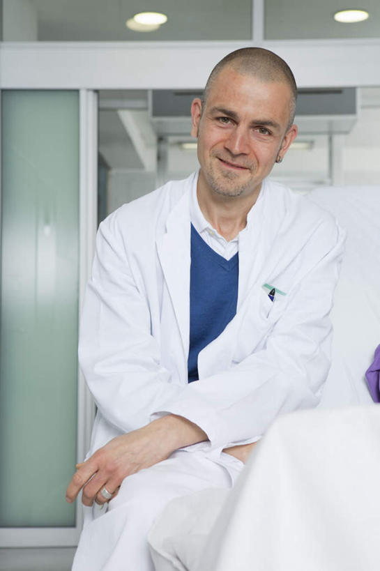 西方人,一个人,医生,坐,笑,微笑,竖图,室内,白天,正面,门,天花板,照明,欧洲,欧洲人,仅一个男性,仅一个人,仅一个中年男性,灯光,注视,顶灯,灯,白色,灯具,门框,观察,看,医护人员,医疗人员,观看,照亮,察看,白大褂,照明设备,关注,男人,男性,中年男性,白种人,大夫,坐着,半身,彩图