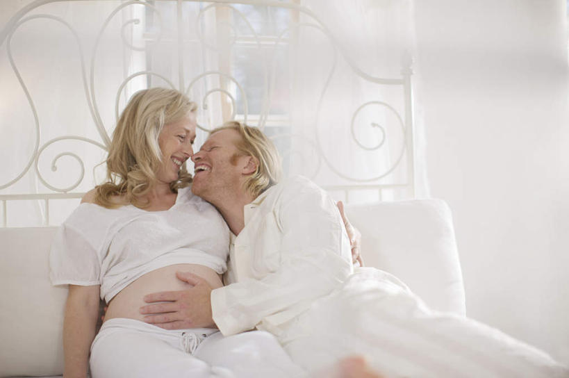 西方人,孕妇,头发,两个人,坐,躺,抱,笑,摸,微笑,露齿笑,横图,室内,白天,正面,床,卧室,欧洲,欧洲人,抚摸,阴影,睡衣,反射,影子,墙,双人床,床单,注视,被子,墙壁,墙面,白色,观察,看,怀孕,金色,抱着,观看,察看,被单,搂着,待产,关注,妊娠,准妈妈,卧着,男人,男性,女人,女性,中年男性,中年女性,白种人,产妇,触摸,接触,搂,搂抱,躺着,卧,坐着,半身,彩图,睡房,卧房