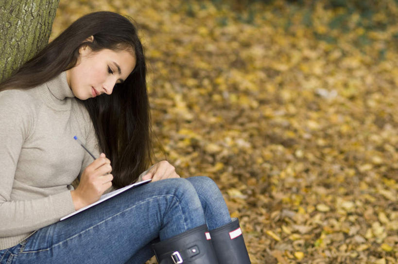 西方人,一个人,坐,横图,室外,白天,侧面,植物,叶子,欧洲,欧洲人,仅一个年轻女性,仅一个女性,仅一个人,握,服装,裤子,笔,枯叶,落叶,办公用品,记事本,拿,拿着,注视,牛仔裤,休闲装,文具,树,树木,衣服,绿色,自然,本子,笔记本,学习用品,观察,看,休闲,休闲服,握着,服饰,生长,成长,观看,文具用品,察看,关注,年轻女性,女人,女性,白种人,叶,叶片,坐着,半身,彩图