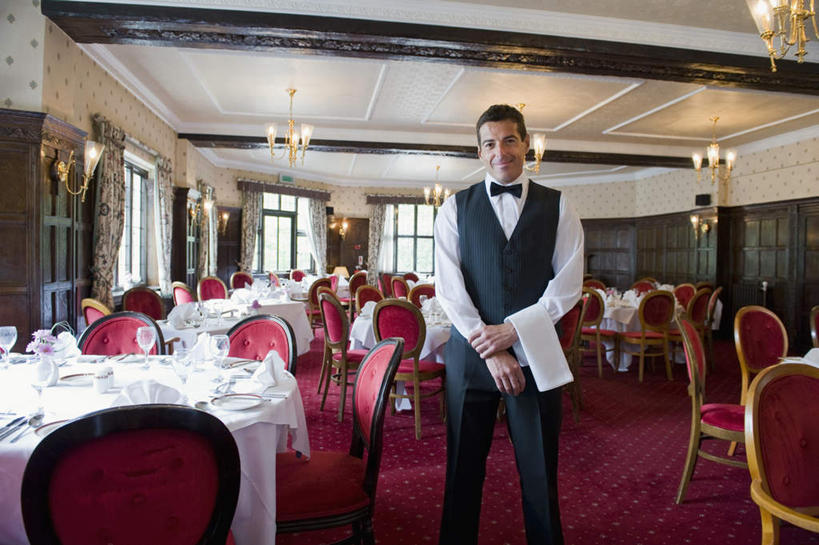 西方人,一个人,服务员,餐厅,站,笑,微笑,横图,室内,白天,正面,工作服,制服,餐桌,窗户,天花板,桌子,椅子,照明,欧洲,欧洲人,仅一个男性,仅一个人,仅一个中年男性,许多,布料,纺织物,领结,墙,灯光,折叠,布纹,注视,吊灯,玻璃窗,墙壁,墙面,灯,桌布,排列,红色,餐巾,灯具,毛巾,台布,观察,看,清洁,手放前,站着,餐台,观看,马甲,保暖,照亮,察看,象征,庄重,照明设备,队列,关注,身份,透气,防水,正式,地位,工作制服,储水,耐磨,吸水,保洁方巾,口布,男人,男性,中年男性,白种人,服务生,侍者,站立,半身,彩图,工作套服,餐馆,饭店,饭馆