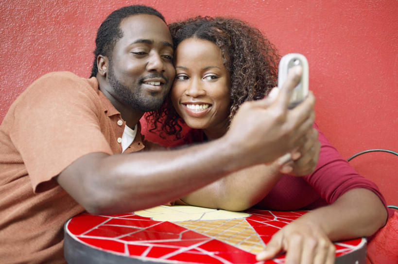 两个人,夫妻,坐,笑,微笑,露齿笑,横图,室内,白天,正面,桌面,桌子,手机,椅子,非洲,黑人,红色背景,花纹,服装,墙,拿,拿着,注视,休闲装,墙壁,衣服,红色,观察,看,休闲,休闲服,恋人,摄影,服饰,影棚,观看,察看,情人,关注,男人,男性,年轻男性,年轻女性,女人,女性,非洲人,夫妇,手提电话,坐着,半身,彩图,影棚拍摄,拍摄,照相