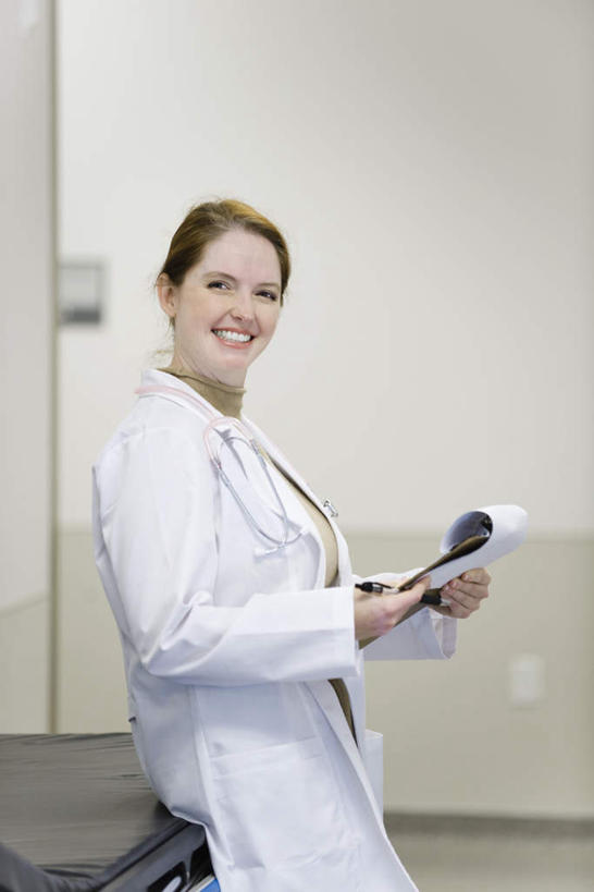 西方人,一个人,医生,医院,站,笑,微笑,露齿笑,竖图,室内,白天,侧面,欧洲,欧洲人,仅一个年轻女性,仅一个女性,仅一个人,握,笔,材料,档案,文件,墙,办公用品,拿,拿着,注视,墙壁,墙面,文具,学习用品,资料,观察,看,靠,靠着,倚靠,站着,医护人员,医疗人员,握着,观看,文具用品,察看,倚着,白大褂,关注,文档,急救床,医疗机构,年轻女性,女人,女性,白种人,大夫,站立,半身,彩图,病院,诊所