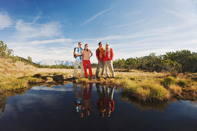 西方人,四个人,伙伴,朋友,站,笑,微笑,露齿笑,横图,室外,白天,正面,友谊,湖,湖泊,山,山脉,水,植物,欧洲,欧洲人,戴,服装,枯萎,包,墨镜,眼镜,湖面,山峰,水流,水面,云,云朵,枯草,山峦,云彩,注视,休闲装,草,树,树木,衣服,黄色,蓝色,绿色,白云,蓝天,天空,自然,背包,太阳镜,太阳眼镜,湖水,群山,天,观察,看,站着,休闲,休闲服,遮阳镜,服饰,生长,晴朗,成长,观看,察看,关注,友情,男人,男性,年轻男性,年轻女性,女人,女性,白种人,晴空,插兜,两手抄兜,两手放兜,手插兜,手放口袋,站立,彩图,全身,双肩包