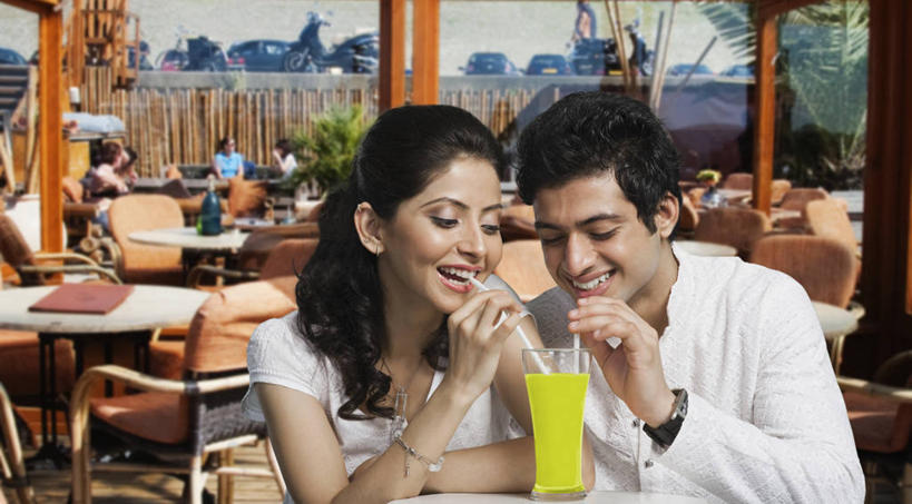 果汁,两个人,餐厅,坐,笑,微笑,露齿笑,横图,室外,白天,正面,民族服装,爱情,餐桌,桌子,杯子,椅子,亚洲,喝,握,服装,塑料,橙汁,饮品,浪漫,拿,拿着,注视,休闲装,玻璃制品,饮料,衣服,黄色,水杯,塑料制品,吸管,观察,看,休闲,温暖,温馨,休闲服,恩爱,握着,恋人,服饰,餐台,观看,和睦,察看,空心,甜橙,关注,可口,饮管,适口,男人,男性,年轻男性,年轻女性,女人,女性,亚洲人,印度人,情侣,玻璃杯,橙子,橙,坐着,半身,彩图,传统服装,民俗服,餐馆,饭店,饭馆,鹄壳,黄橙,黄果,金橙,金环,金球,糖橙,伴侣,融洽,圆柱状