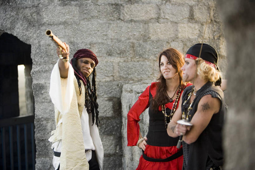 西方人,三个人,伙伴,朋友,站,举,笑,双手交叉,微笑,露齿笑,横图,室外,白天,正面,戏服,爱情,时尚,游戏,友谊,竞争,建材,建筑,项链,欧洲,非洲,黑人,欧洲人,表演,对抗,握,服装,冲突,材料,枪支,头巾,砖,砖块,墙,浪漫,玩,注视,破坏,文化,娱乐,纹身,墙壁,墙面,装饰品,衣服,戒指,饰品,首饰,观察,看,托,站着,休闲,眯眼,武器,砖头,恩爱,个性,战争,眯,握着,建造,服饰,手枪,信仰,观看,活动,信物,损坏,察看,双手抱胸,剑,攻击,权利,威胁,衣着,穿着,对立,发泄,关注,矛盾,消遣,智力,兵器,刺青,追求,防御,角色扮演,表演服,枪械,演出服,想象,弹夹,敌对,挫败,斗争,抗拒,抗衡,文身,勇气,崇拜,张扬,宣泄,杀伤,威慑,手饰,衣饰,子弹夹,演戏,道具服,危险,友情,男人,男性,年轻男性,年轻女性,女人,女性,白种人,非洲人,石料,举起,举手,举着,玩耍,嬉戏,向上举,向上伸,向上托,站立,半身,彩图,砌墙砖