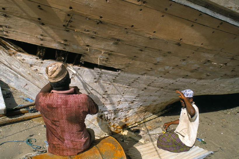 两个人,坐,横图,室外,白天,沙滩,船,帽子,阿曼,亚洲,握,阴影,服装,光线,钉子,木板,沙子,影子,海岸,木船,沙地,拿,拿着,注视,休闲装,背面,衣服,阳光,绳子,遮阳帽,交通工具,观察,看,休闲服,握着,服饰,观看,绳索,五金,察看,舟,紧固,关注,载具,西亚,牢固,阿曼苏丹国,修补,男人,男性,中年男性,阿拉伯人,白种人,亚洲人,海滩,坐着,彩图,全身,稳固