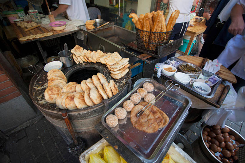 点心,面食,煎饼,东方人,四个人,店员,商店,站,交叉,横图,俯视,室外,白天,早餐,厨具,金属制品,亚洲,一堆,一排,许多,阴影,堆叠,堆积,服装,朦胧,模糊,整齐,环绕,围绕,编织,光线,金属,篮子,铁桶,桶,影子,蛋,谷类,谷物,鸡蛋,油炸,芝麻,料理,食品,糯米,水煮蛋,米,很多,球形,环抱,休闲装,黄种人,商铺,大米,饼,美食,顾客,球,茶叶蛋,食物,排列,衣服,阳光,夹子,容器,站着,营业员,休闲,球体,休闲服,中式,早点,服饰,麻花,储藏,油条,堆,灶具,交织,储存,队列,燃气灶,麻球,粢饭糕,脂麻,胡麻,白麻,巨胜子,食品夹,食物夹,面包夹,意粉夹,油麻,卵,市肆,商号,萦绕,销售人员,燃气具,穿插,江米,主顾,煎堆,麻圆,五香茶叶蛋,五香蛋,男人,男性,年轻男性,年轻女性,女人,女性,亚洲人,售货员,站立,半身,彩图,高角度拍摄,早饭,店铺,油果子,油馍,油炸果,油炸桧,油氽粢饭糕,炸糍粑,鸡卵,鸡子,贮存