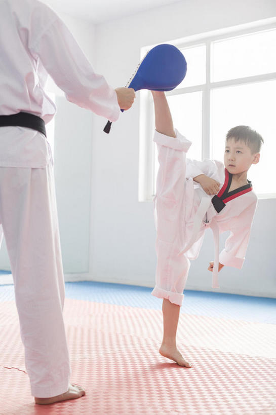 年轻教练教小男孩跆拳道